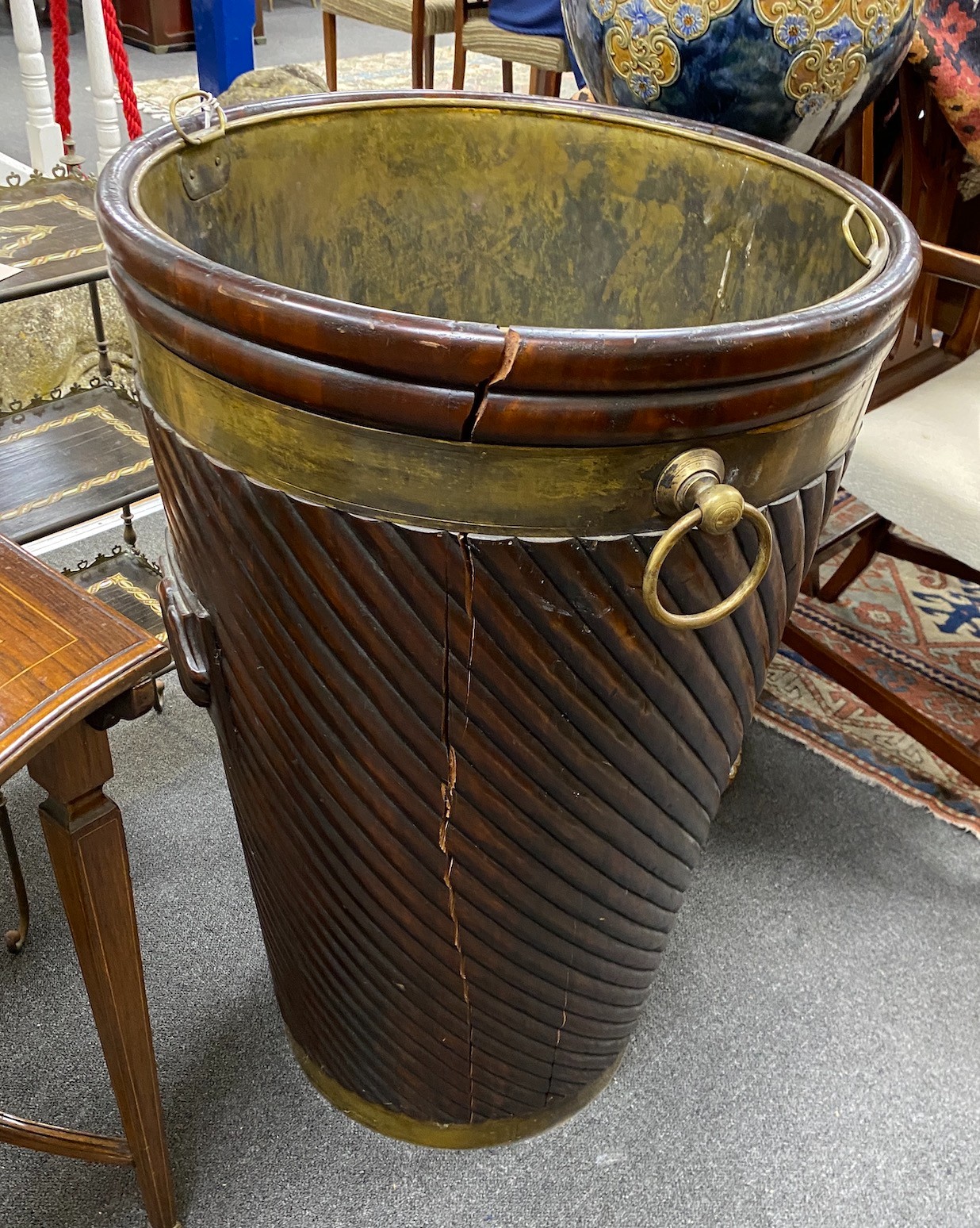 A large George III style brass mounted mahogany peat bucket, with wrythen fluted body and brass liner, diameter 55cm, height 86cm